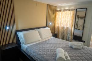 una camera da letto con un letto con due asciugamani sopra di Meravigghia Syracusae Home a Siracusa