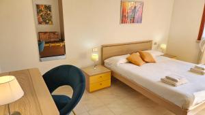 una camera da letto con un letto, un tavolo e una sedia di APARTMENT ORTENSIA - Regarda Travel a Lazise Altre 31 foto