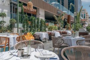 a restaurant with white tables and chairs and a building at Radisson Beach Resort Palm Jumeirah in Dubai