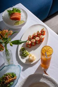 a table with plates of food and a drink at Radisson Beach Resort Palm Jumeirah in Dubai