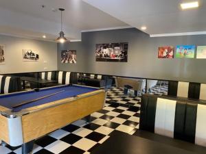 a room with a pool table on a checkered floor at Hotel San Carlos in San Antonio de Areco