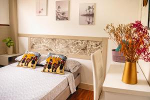 - une chambre avec un lit et un vase avec des fleurs dans l'établissement Villa 97 guayaquil Suites y Habitaciones Económicas Cerca del Aeropuerto, à Guayaquil