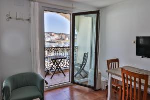 a living room with a balcony with a table and chairs at Apartamentos Arnela in Camariñas