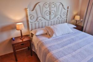 a bedroom with a bed and a lamp on a table at Apartamentos Arnela in Camariñas