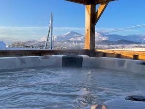 ein Whirlpool mit Blick auf eine Brücke in der Unterkunft Roddys cottage three bedroom with hot tub sleeps6 in Magherasaul