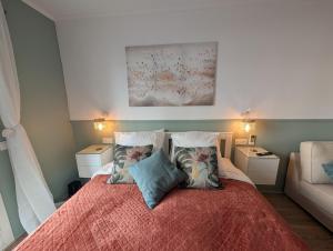 a bedroom with a bed with pillows and a couch at Luxury studio next to beaches and old town Antibes in Antibes