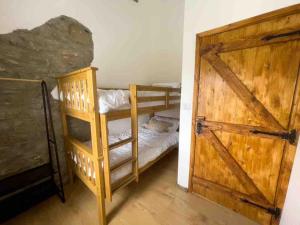 Zimmer mit 2 Etagenbetten und einer Holztür in der Unterkunft Roddys cottage three bedroom with hot tub sleeps6 in Magherasaul