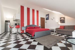 a bedroom with a red bed and a checkered floor at La Mansarda del Principe, vicoli, acquario e lanterna in Genoa