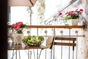 a balcony with a table with a bowl of fruit and flowers at Centro di Centri Rooms in Split