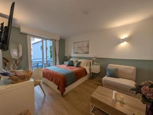 a bedroom with a bed and a couch and a television at Luxury studio next to beaches and old town Antibes in Antibes +34 photos