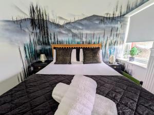 a bedroom with a large bed with a painting on the wall at Cwmcarn Hotel & Bunkhouse in Cwmcarn +49 photos