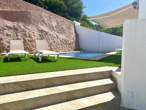 two chairs and a swimming pool in a backyard at Casa Marga By Solymar Holiday in Canillas de Aceituno