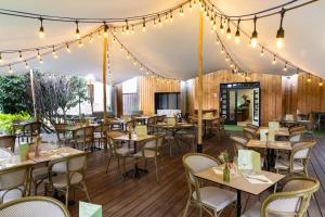 a dining room with tables and chairs and lights at Hôtel Restaurant Les Boissières in Bioule