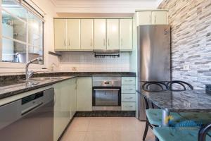 eine Küche mit einem Kühlschrank aus Edelstahl und einem Tisch in der Unterkunft Casa Noray del Mar in Castillo del Romeral