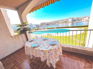 a table on a balcony with a view of the water at Maena San Maurici Lago in Empuriabrava