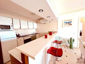 a kitchen with a counter and a red stool at Maena San Maurici Lago in Empuriabrava
