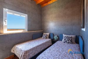 ein Schlafzimmer mit zwei Betten und einem Fenster in der Unterkunft Casa Noray del Mar in Castillo del Romeral + 22 Fotos