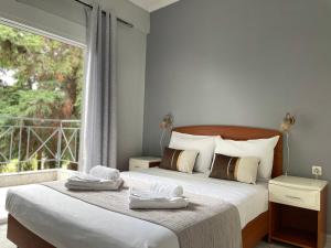 a bedroom with two beds and a large window at DOMES APARTMENTS in Kallithea Halkidikis