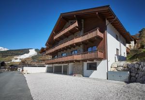 a building with a balcony on the side of a road at Life & Luxury Appartements in Saalbach Hinterglemm
