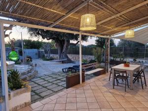 a patio with a table and a wooden ceiling at Villa Anna Polignano in Polignano a Mare