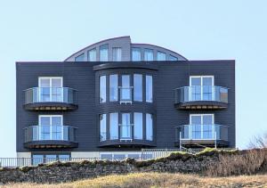 a black building with balconies on the side of it at cellar cove in Perranporth
