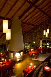 a large room with tables and a large fireplace at Le Relais de la Reine de l'Isalo in Ranohira