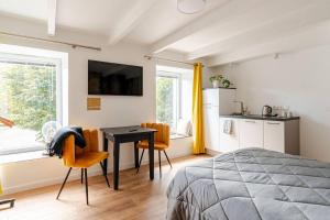a bedroom with a bed and a table and chairs at Agréable studio pour 2 personnes Studio Melen in Saint-Thurien