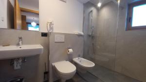 Un baño con inodoro, lavabo y ducha. en Residence Eden, en Sesto