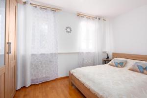 Apartment Valencia في كارلوفي فاري: غرفة نوم بيضاء مع سرير ونافذة