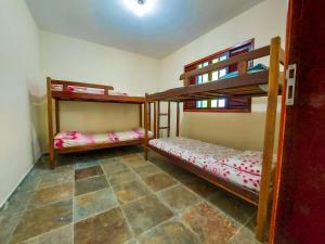 a room with two bunk beds and a tile floor at Casa - Temporada in Guarapari