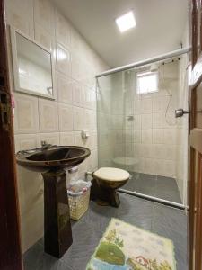 a bathroom with a sink and a toilet at Casa - Temporada in Guarapari