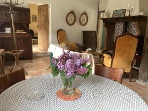 a vase of purple flowers sitting on a table at Cabane de charme in Losse
