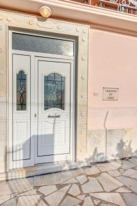 Veranda Syros House في إرموبولّي: باب أبيض على مبنى فيه مقاعد