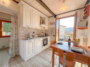 a kitchen with white cabinets and a table and a dining room at La Botte - Original Tuscany Duplex in Compiobbi