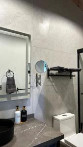 Un baño con lavabo, espejo e inodoro. en Chalet de Montaña con Jacuzzi y Futbolito, en Mazamitla