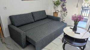 a couch in a living room with a table at Lilac Kefalos in Kefalos