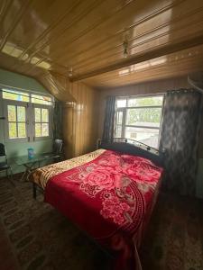 a bedroom with a bed with a red bedspread at Shahdaar inn in Srinagar