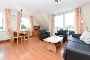a living room with a couch and a table at Haus Andreesen in Neuharlingersiel