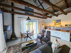 a living room with a table and a kitchen at Rumali Farm & Cottage in Montagu