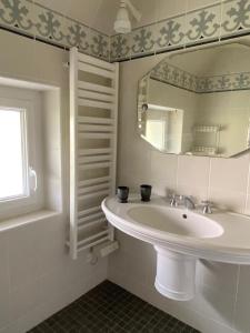un bagno bianco con lavandino e specchio di Ty Mamm Doué a Ploubazlanec