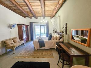 une chambre avec un lit, un miroir et un bureau dans l'établissement Rumali Farm & Cottage, à Montagu