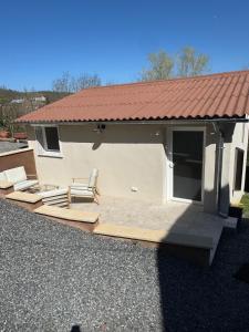 a house with a deck with a chair on it at La Loubière - le gîte au cœur de la nature in Combret