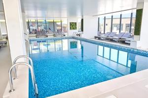 a large swimming pool with blue water in a building at Alezi Apartamente in Mamaia Sat/Năvodari