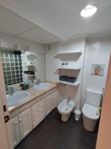 a bathroom with two sinks and a toilet at Puerta Ibiza in Denia