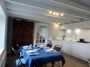 un tavolo con una tovaglia blu in cucina di Ty Mamm Doué a Ploubazlanec Altre 12 foto