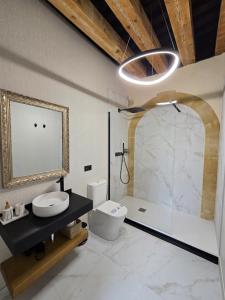 a bathroom with a sink and a toilet and a mirror at El capricho Balcón en la Plaza Mayor Salamanca Collection Luxury in Salamanca +58 photos