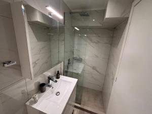 イラクリトサにあるÉva Apartman houseの洗面台とシャワー付きの白いバスルーム +17枚の写真