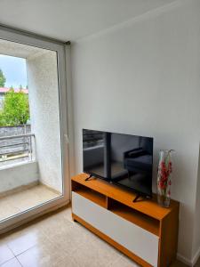 a flat screen tv sitting on a dresser next to a window at Departamento Corcovado in Puerto Montt