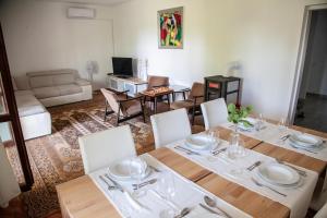 una sala da pranzo con tavolo e sedie e un soggiorno di Olivia apartment, Zambratija a Zambratija