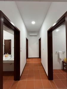 a hallway of a bathroom with a sink and a mirror at Casa da Cabração - Circuito Aldeias de Portugal in Ponte de Lima